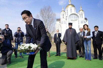 Japanese Prime Minister Fumio Kishida, front, lays the flowers at a church in Bucha, a town outside Kyiv that became a symbol of Russian atrocities against civilians, on March 21, 2023.