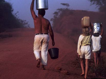 A family carries buckets of water on the Transamazon highway in the State of Pará (northern Brazil).