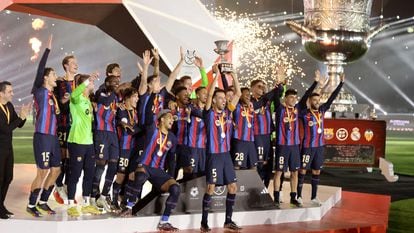FC Barcelona's Sergio Busquets lifts the trophy as he celebrates with teammates after winning the Spanish Super Cup.