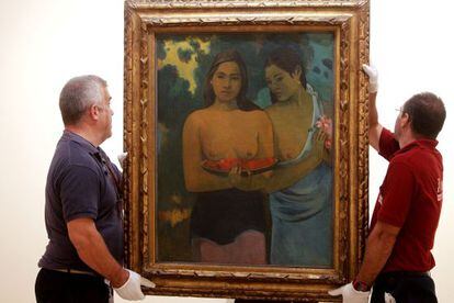 Two Thyssen workers hang Gauguin&#039;s &#039;Two Tahitian Women&#039; at the exhibition.