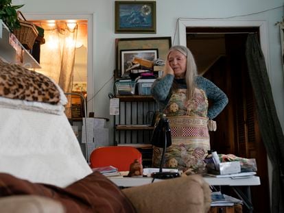 Nancy Rose, who contracted Covid-19 in 2021 and exhibits long-haul symptoms including brain fog and memory difficulties, pauses while organizing her desk space, Tuesday, Jan. 25, 2022, in Port Jefferson, N.Y.