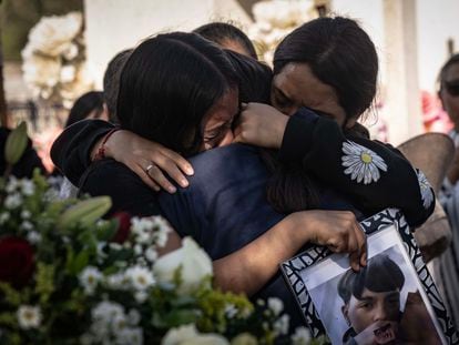 Relatives of Oscar Ernesto Rojas Alvarado hug during his burial in Malpaso cemetery.