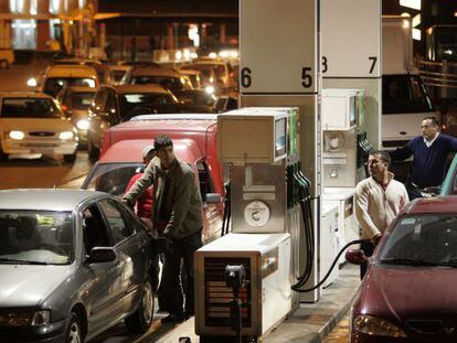 Drivers line up to fill their tanks at a gas station.