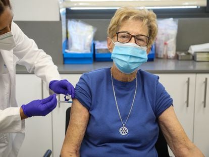 A senior in Madrid receives a Covid-19 booster shot and flu vaccine, in a file photo from October 2021.
