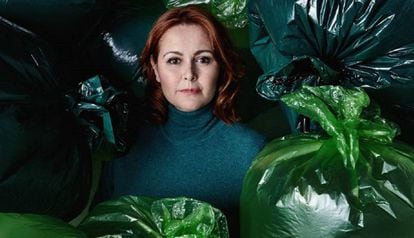 María Gallay surrounded by trash bags.