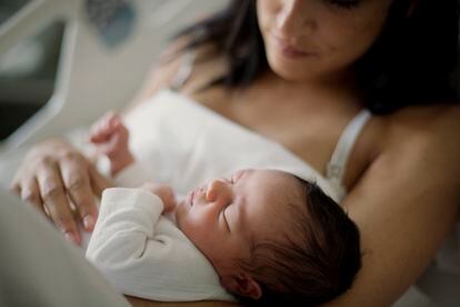 A newborn girl sleeps in her mom arms at the Sant Pau hospital in Barcelona.