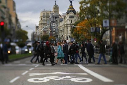 Pedestrians cross Gran Vía avenue, which is part of the Madrid Central zone.