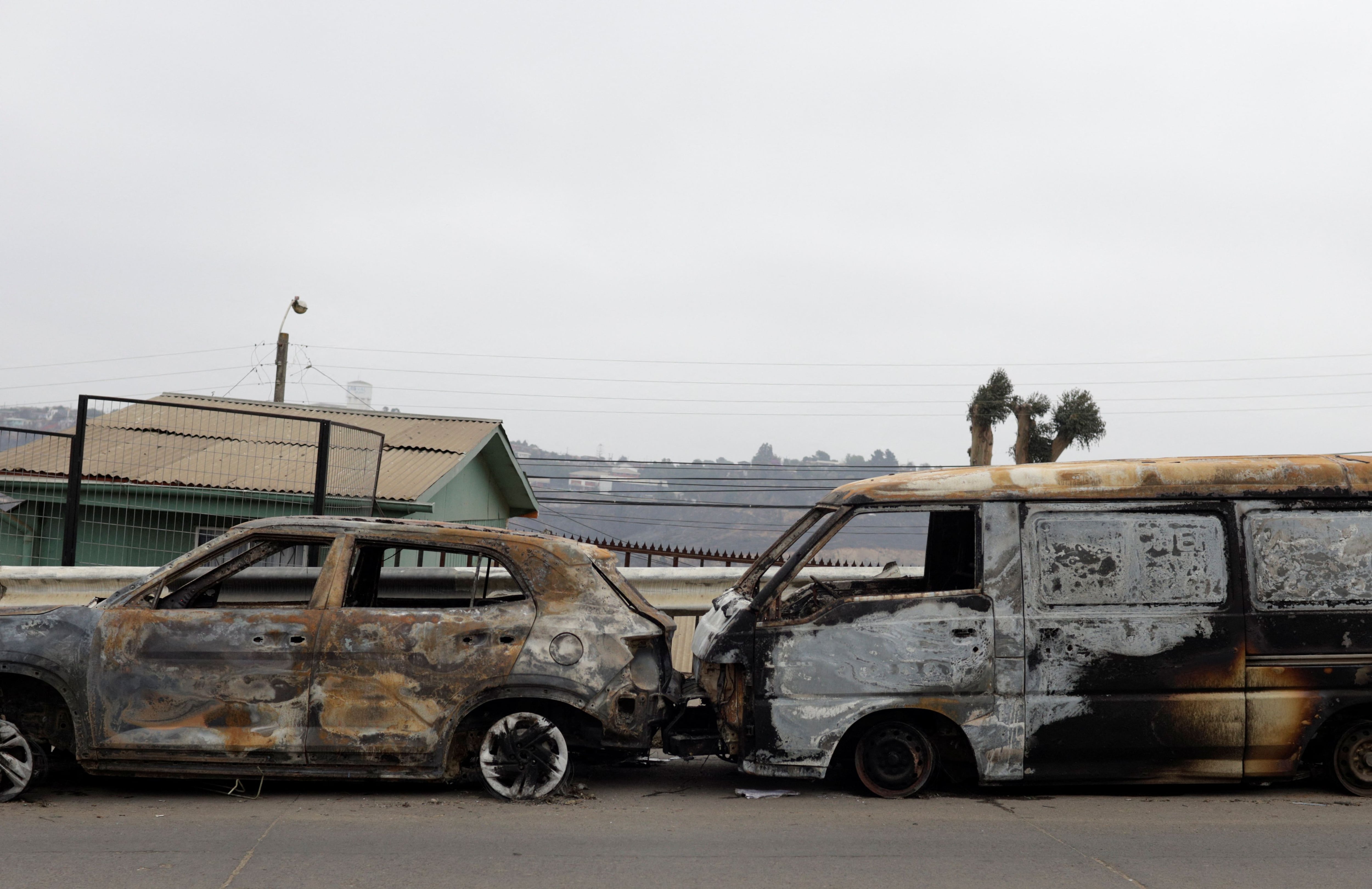 The charred remains of two cars on the side of a road on Sunday in Viña del Mar.