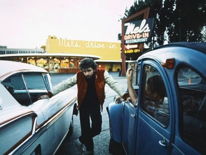 George Lucas poses between two cars during the filming of ‘American Graffiti’ in San Francisco in 1973.