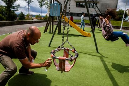 A man disinfects a swing in a playground in Santiago de Compostela in Galicia, which lifted the state of alarm on Monday.