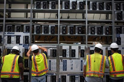Workers at a bitcoin miner in Winston, Texas.