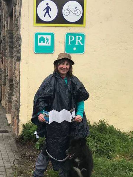 Mari Carmen Astigarraga shows her “pilgrim” certificate, next to Neo, upon their arrival at Santiago de Compostela.