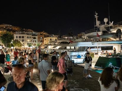 Tourists observing private yachts at the port of Ibiza in August.