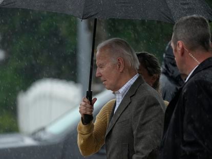 President Joe Biden walks with Annie Tomasini in the rain from St. Edmond Roman Catholic Church after attending Mass in Rehoboth Beach, Del. Saturday, May 13, 2023.