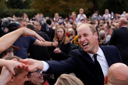 Following Queen Elizabeth’s death, Prince William, the heir to the British throne, receives affection from the crowd gathered outside Windsor Castle.