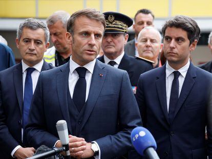 French President Emmanuel Macron (center) talks to the press after a visit to the Gambetta high school in Arras, France, October 13, 2023.