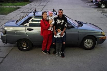 Constantin, Ina and their children Danil and Vladislava next to the Lada car in which they escaped the Russian occupation in the Kherson region.