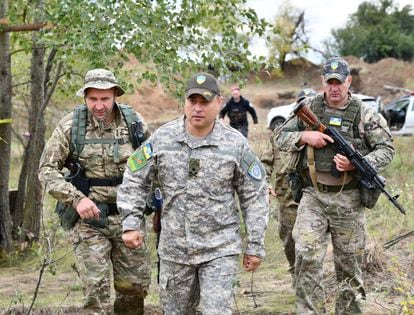 The Ukrainian general Sergei Melnik visits the front escorted by several soldiers.