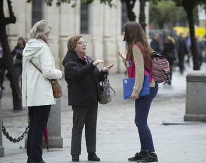 A street fundraiser tries to convince two women to sign up.
