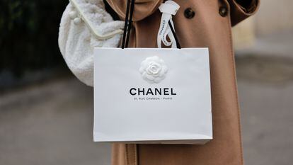 A woman carries a Chanel bag, which could be resold in the emerging market for luxury paper bags.