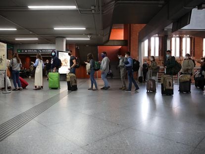 Passengers wait in line for a train at Madrid's Atocha station on Friday afternoon.