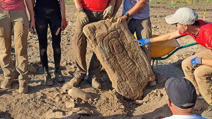 An archaeologist points to the stela featuring the diadem found at Las Capellanías site in Huelva.