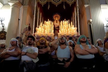 The ‘costaleros,’ or men who carry the processional floats, of the María Santísima de la Fe y Caridad congregation, watch the carrying out of the Santa Cena ‘paso’ in Almería, on March 25.