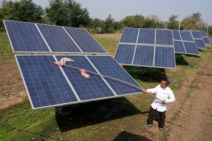 Farmer Pravinbhai Parmar cleans a solar panel installed at a farm in Dhundi village of Kheda district in western Indian Gujarat state, India