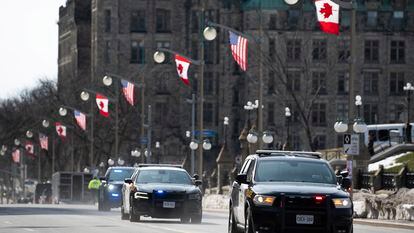 Ontario Provincial Police vehicles speed along Wellington Street in preparation of U.S. President Joe Biden's visit in Ottawa, Ontario, on Wednesday, March 22, 2023.