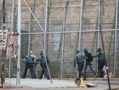 Spanish Civil Guard officers march two immigrants back to Morocco on February 19.