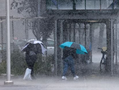 People walk in the rain as the remnants of Tropical Storm Ophelia bring flooding across the mid-Atlantic and Northeast, in New York City, U.S., September 29, 2023.