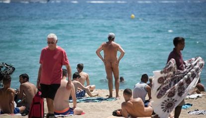 A nudist on Mar Bella beach surrounded by clothed bathers.
