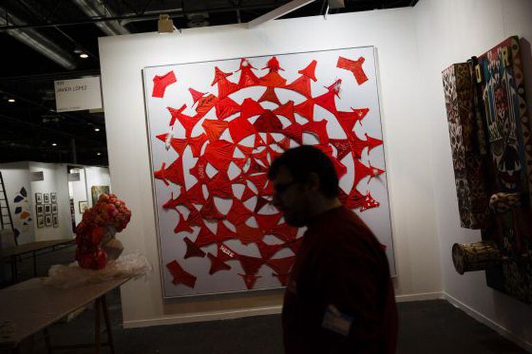 An art dealer walks through the stands at Arco.