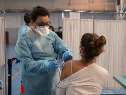 A health worker administers the first dose of the AstraZeneca vaccine to a teacher in Seville.