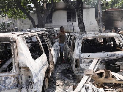 A man looks at the charred remains of vehicles near the presidential palace, after they were set on fire by gangs, in Port-au-Prince, Haiti March 25, 2024.