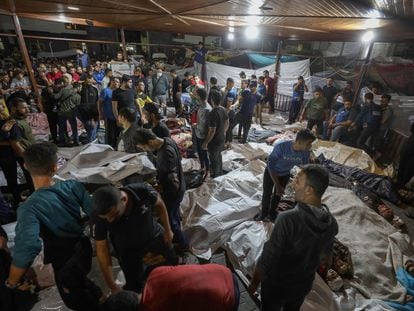 People gather around the bodies of Palestinians killed in Israeli airstrikes on the Al Ahli Arab Hospital in central Gaza, after being transported to Al-Shifa Hospital, October 17, 2023.