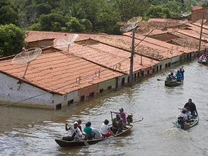 FILE - People travel by boat in a flooded street in Trizidela do Vale, state of Maranhao, Brazil, May 9, 2009. The intensity of extreme drought and rainfall has “sharply” increased over the past 20 years, according to a study published Monday, March 13, 2023, in the journal Nature Water. (AP Photo/ Andre Penner, File)