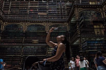 Visitors and tourists photograph the main hall of the Real Gabinete Português de Leitura.