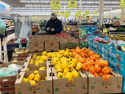 A man looks at his mobile phone while shopping at a grocery store in Buffalo Grove, Illinois, on March 19, 2023.
