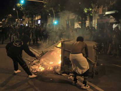 Two youths set up a fire barricade in the Sants neighborhood.
