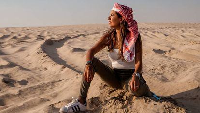 Mariel Galán sitting in the dunes of the Qatari desert.