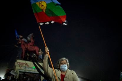 A woman with a Mapuche flag celebrates the results of the referendum to write a new Constitution.