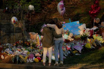 Community members embrace while visiting a memorial at the school entrance after a deadly shooting at the Covenant School in Nashville, Tennessee