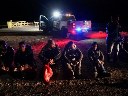 Migrants wait to be processed after crossing the border, Jan. 6, 2023, near Yuma, Ariz.