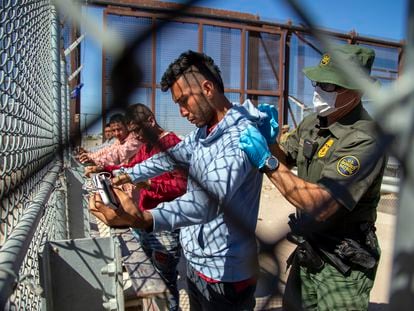Migrants are pat down by a Border Patrol agent as they enter into El Paso, Texas from Ciudad Juárez, Mexico, on May 10, 2023.