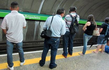 Male passengers eye two girls on the São Paulo metro system.
