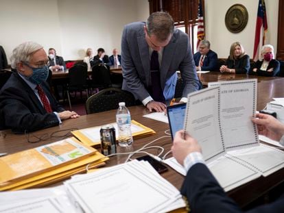 Shawn Still, now a Georgia Republican state senator, leans over to sign electoral certificates voting for Donald Trump and Vice President Mike Pence at the Georgia Capitol, Dec. 14, 2020, in Atlanta.