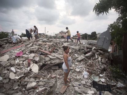 Survivors of Saturday's earthquake stand amid the ruins of their homes.