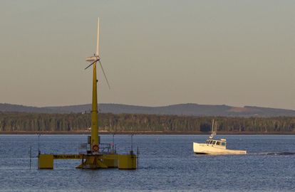 A lobster boat passes the country's first floating wind turbine off the coast of Castine, Maine, Sept. 20, 2013