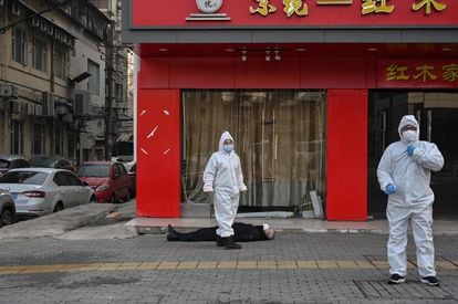A man lies on a street in Wuhan in January 2020.